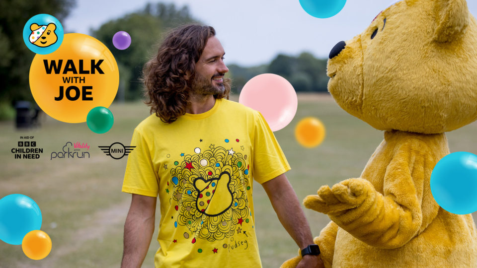 Picture of Joe Wick The Body Coach looking and smiling at Pudsey the Bear