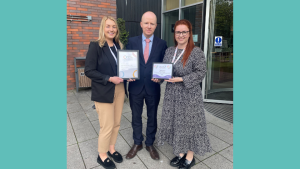 Gemma and Marthe from Dundee Carers Centre present a Carers Charter and Respitality Certfiicate to the Manage of Apex Hotel in Dundee.