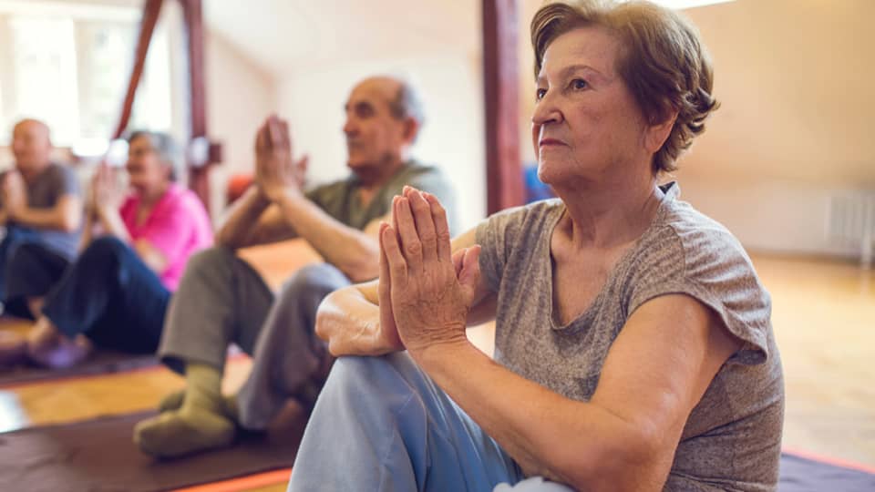 Group with older people in a yoga class.